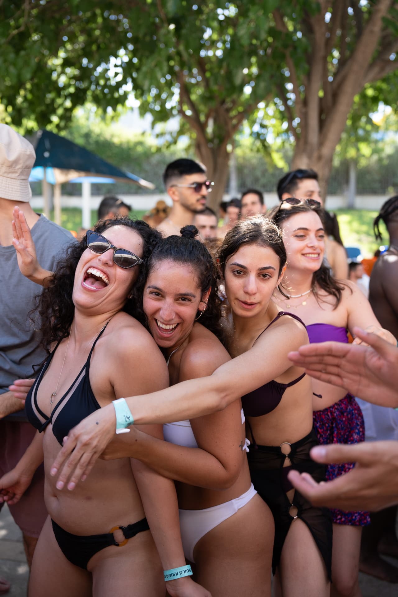 רקדניות מחובקות וצוחקות במסיבת הבריכה